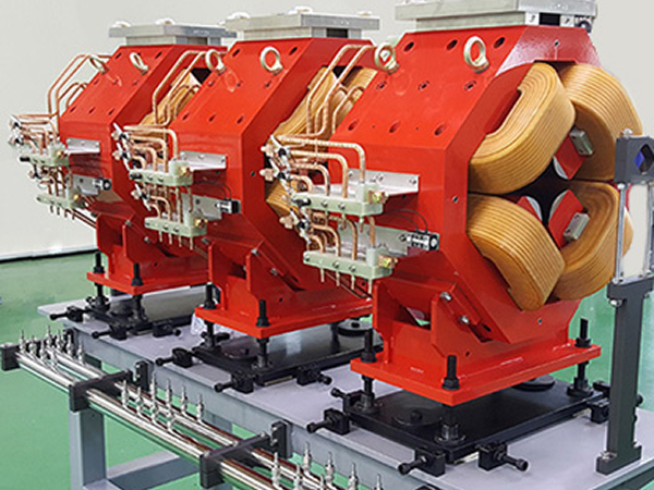 Row of completed quadrupole magnets lined up in the assembly area