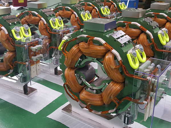 Detailed view of a green sextupole magnet showing six copper coil sections