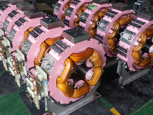 Line of pink sextupole magnets assembled on metal support stands
