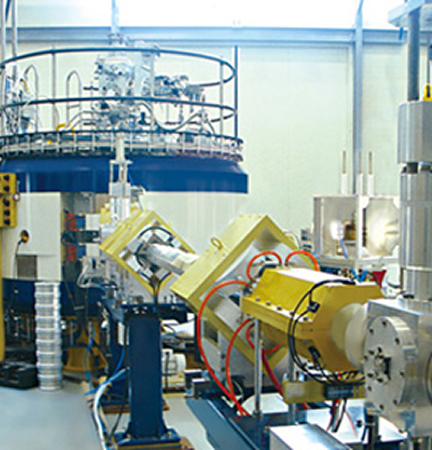 Cyclotron magnet system connected to beamline equipment inside a research lab
