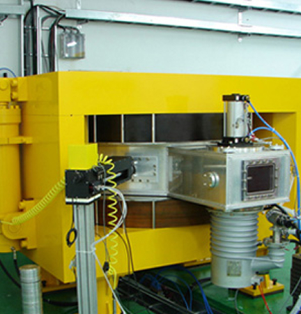 Large yellow cyclotron magnet assembly with vacuum chamber components